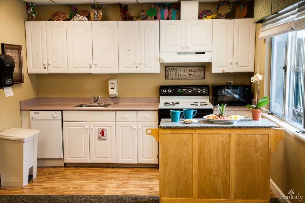 A well-equipped kitchen featuring white cabinets, a stove, and a microwave.