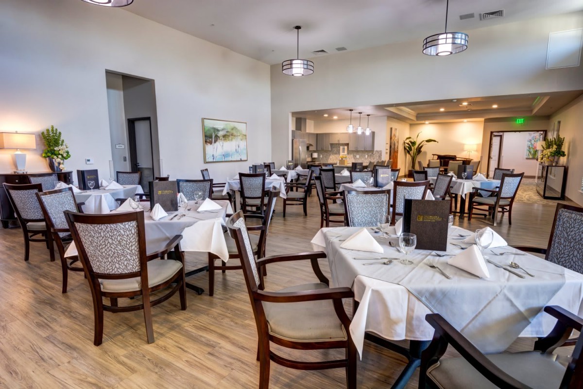 An elegantly set dining area in a restaurant with neatly arranged tables and chairs.
