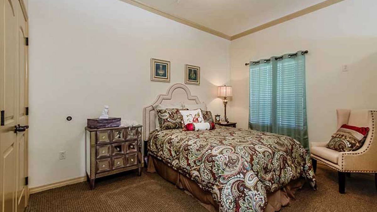 A cozy bedroom with patterned bedding and warm lighting.
