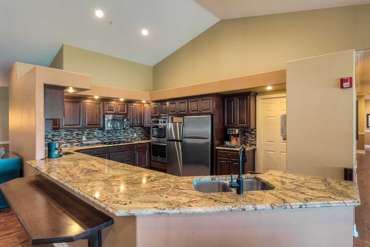 A modern kitchen with granite countertops and stainless steel appliances.