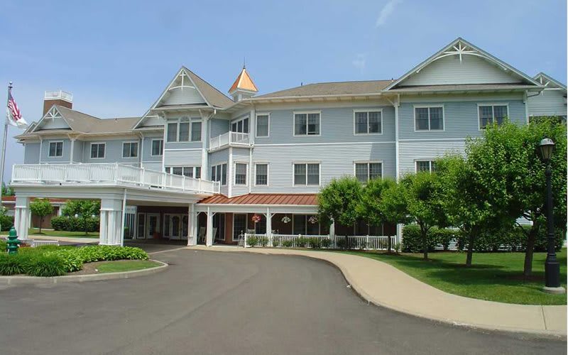 A large residential building with a landscaped entrance and driveway.