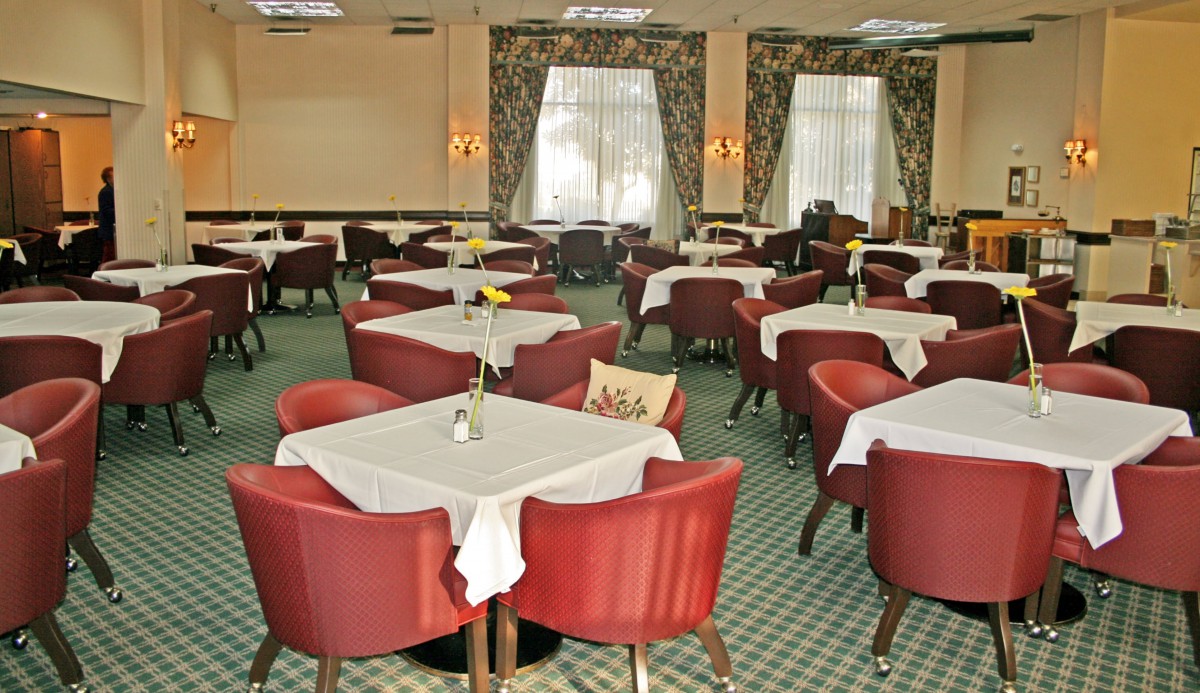 An elegantly arranged restaurant dining room with neatly set tables and comfortable chairs.