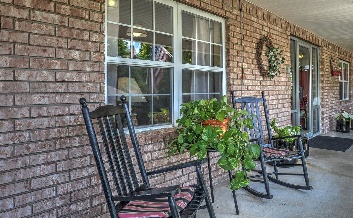 A cozy porch with rocking chairs and a hanging plant.