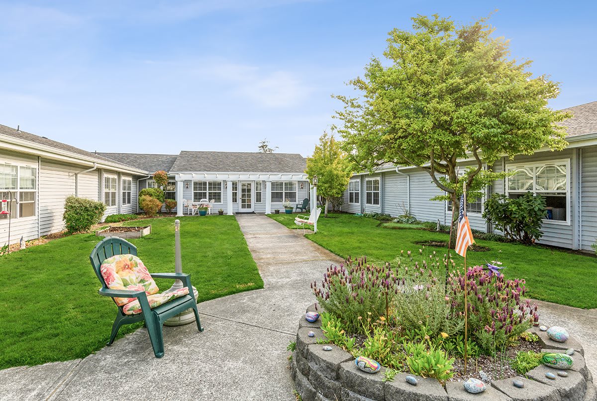A serene courtyard with a landscaped garden and outdoor seating on a sunny day.