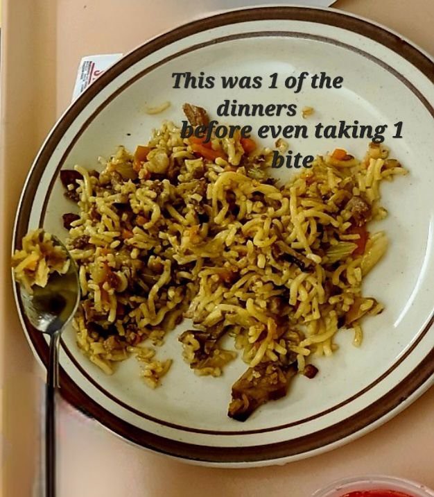 A plate of noodles and vegetables before being eaten.