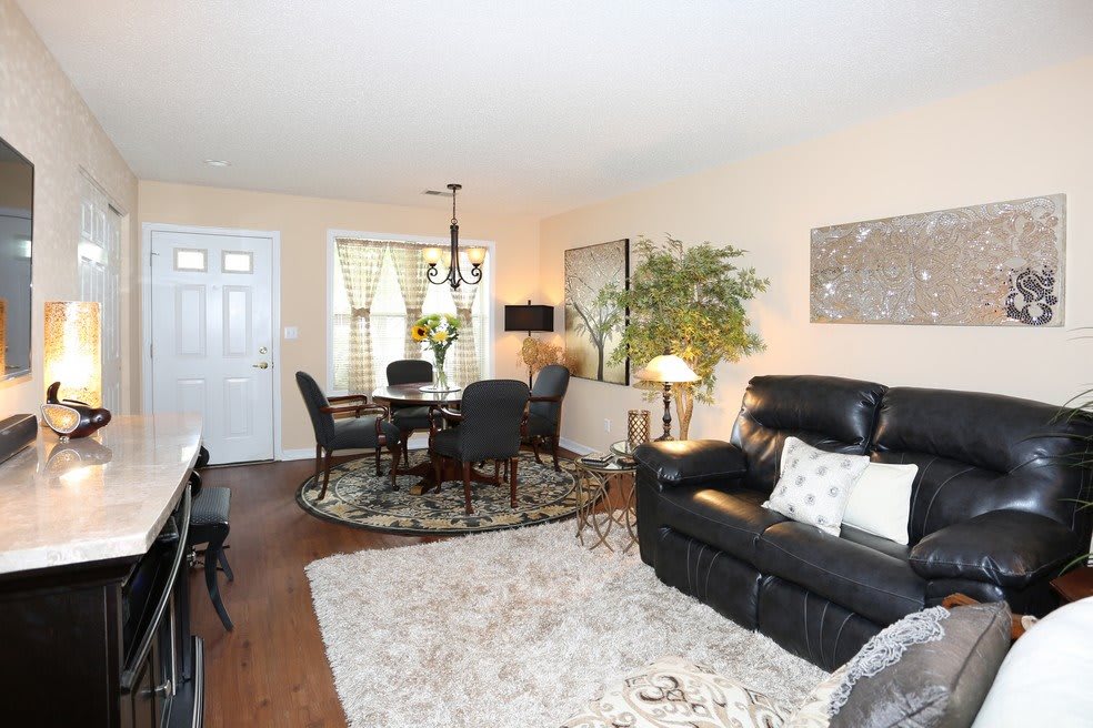 A cozy living room with a dining area, featuring elegant decor and comfortable furniture.