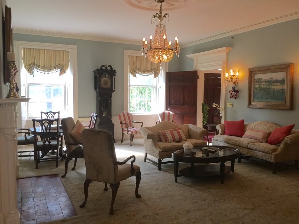 A classic living room with elegant furniture and a chandelier.