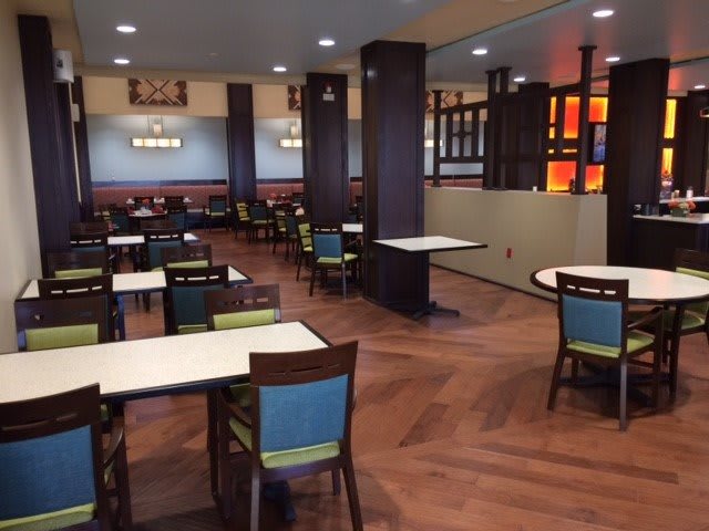 An empty restaurant dining area with neatly arranged tables and chairs.