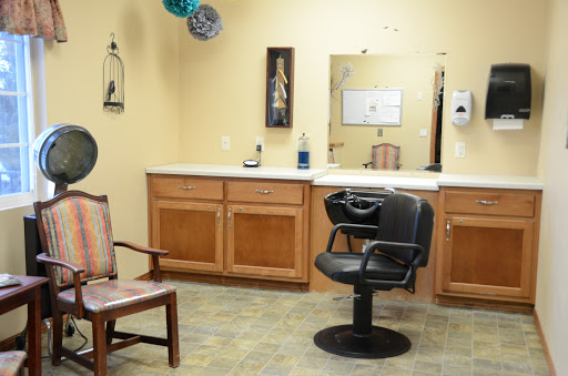 A view of a hair salon featuring a styling chair and waiting area.