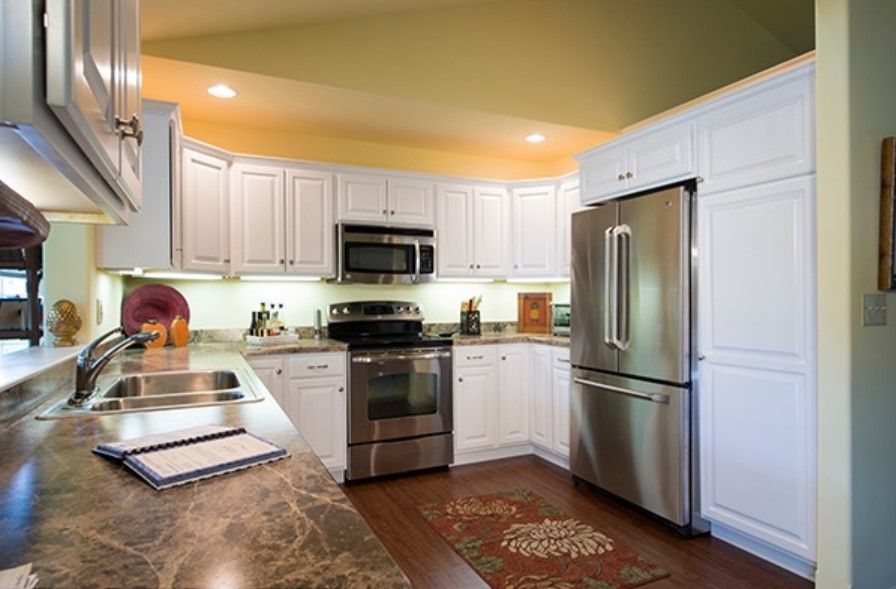 A modern kitchen with stainless steel appliances and white cabinetry.