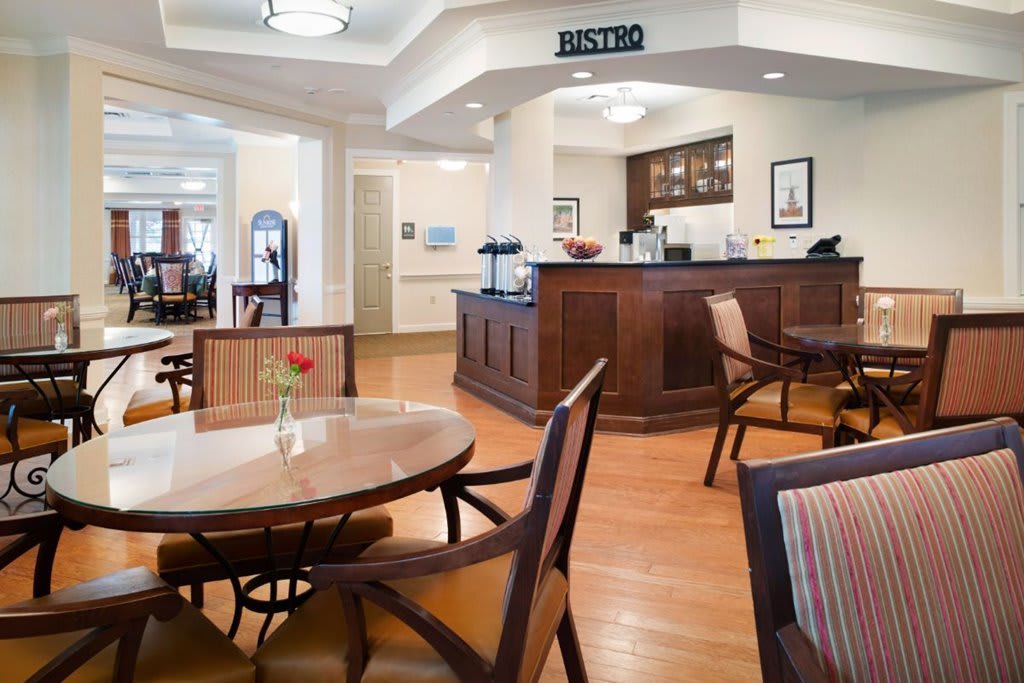 A cozy bistro interior with tables and chairs arranged neatly around a service counter.