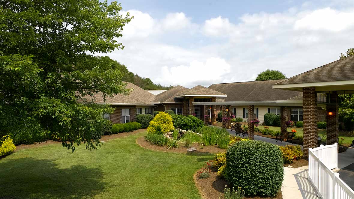 A single-story house with a well-maintained garden and lawn on a cloudy day.