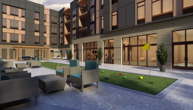 A modern apartment complex featuring outdoor seating and landscaped areas.