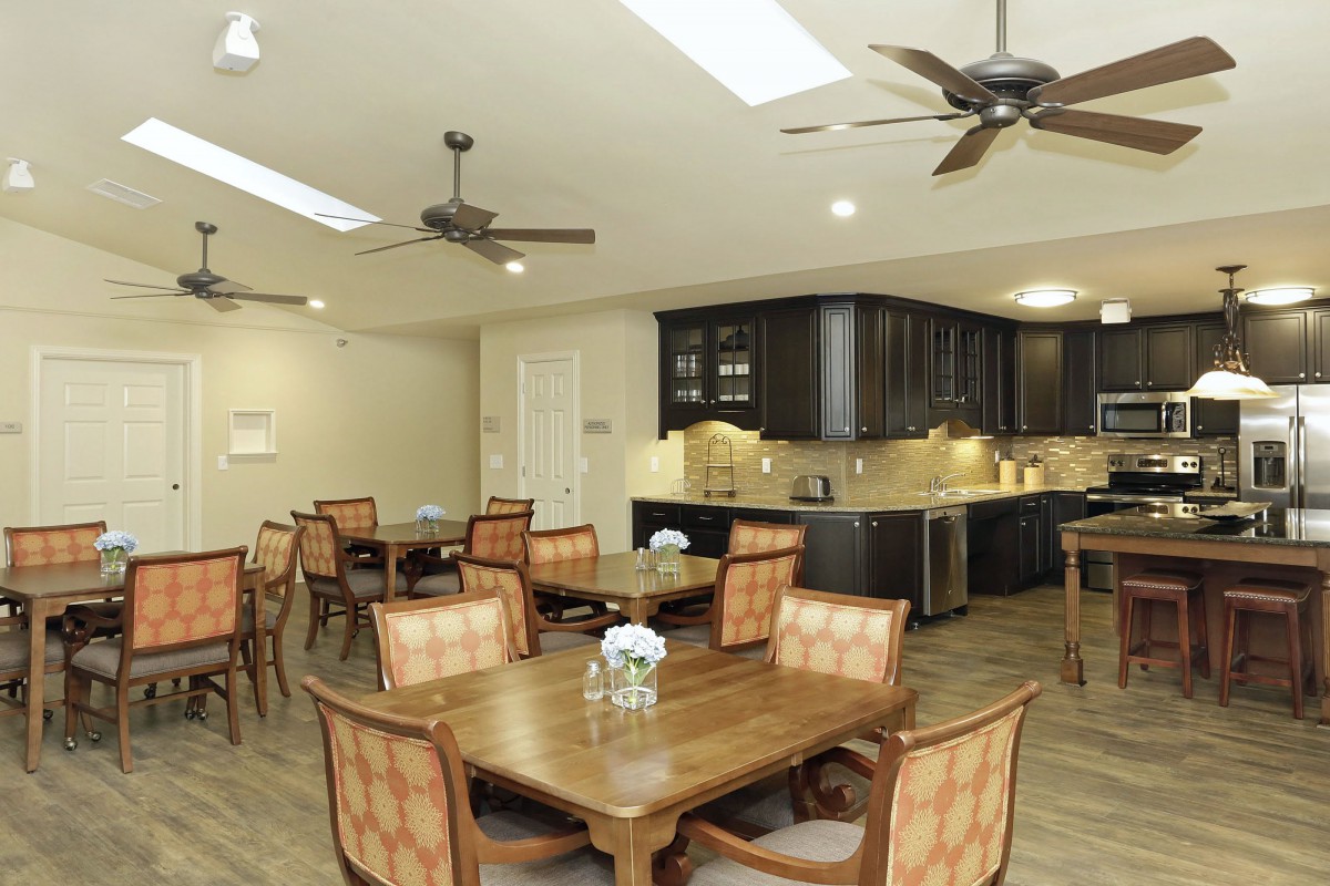 A modern kitchen and dining area with wooden furniture and ceiling fans.