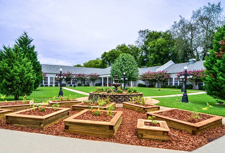 A beautifully landscaped garden with well-maintained pathways and lush greenery in a courtyard setting.