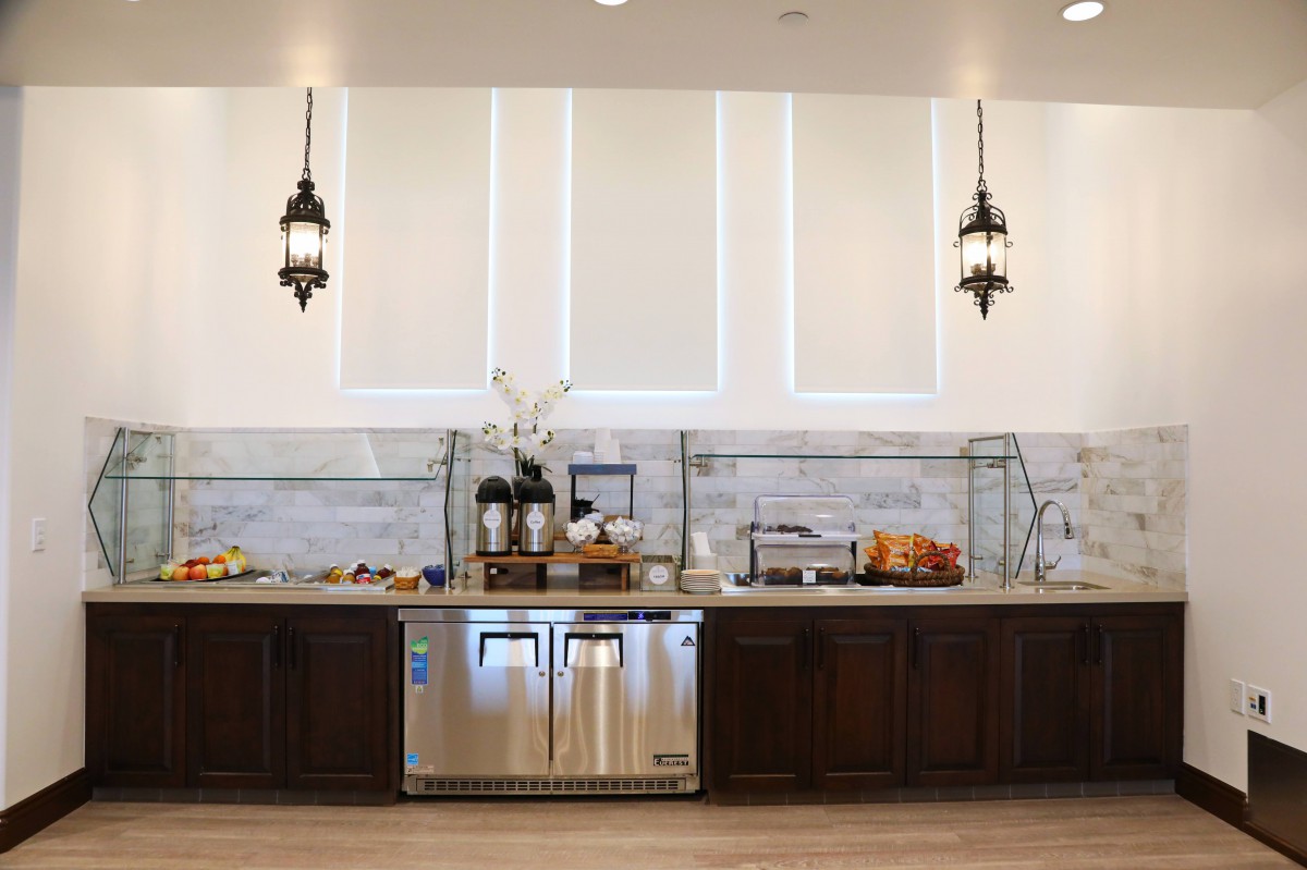 Buffet setup with various food items and beverages in a well-lit dining area.