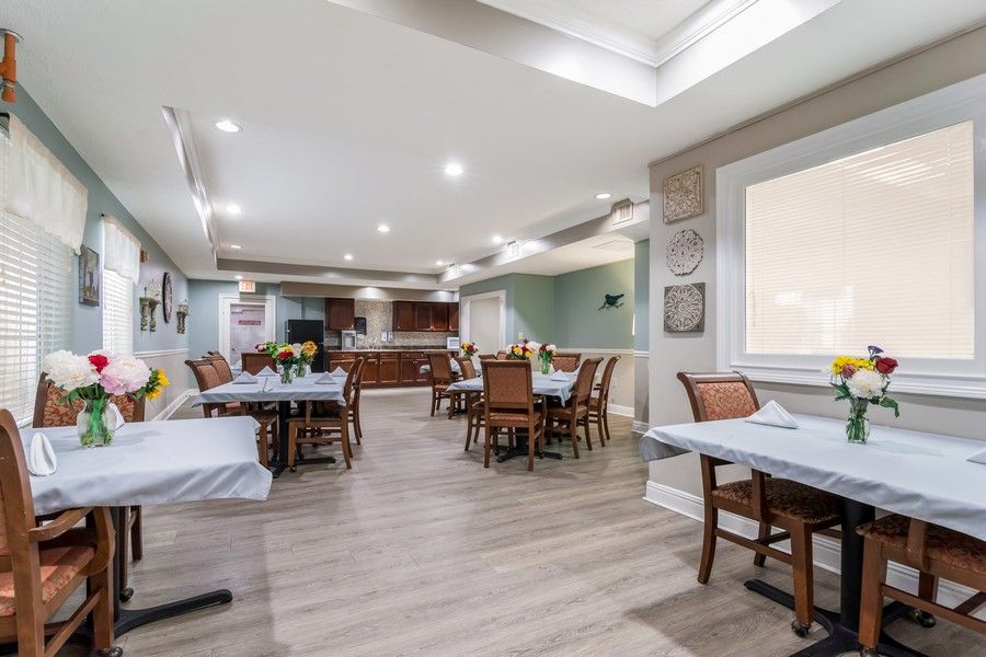A modern and spacious dining area with neatly arranged tables and chairs, featuring elegant interior design.