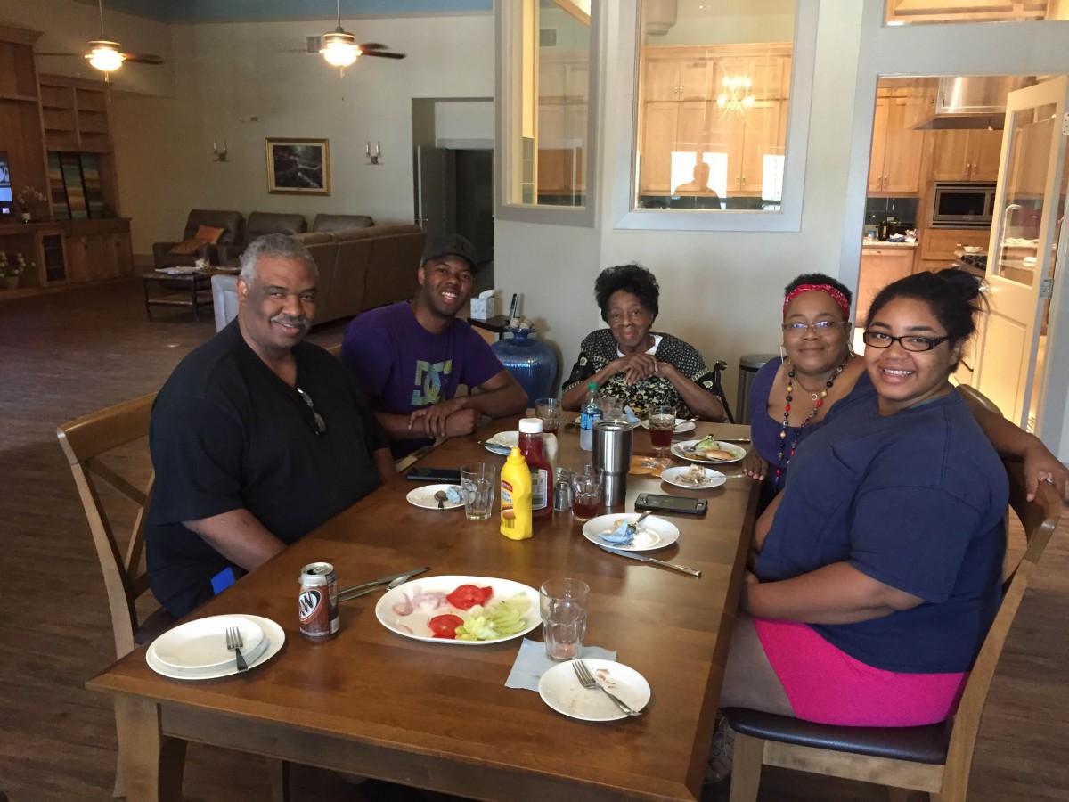 A family enjoying a meal together at a dining table with smiles.
