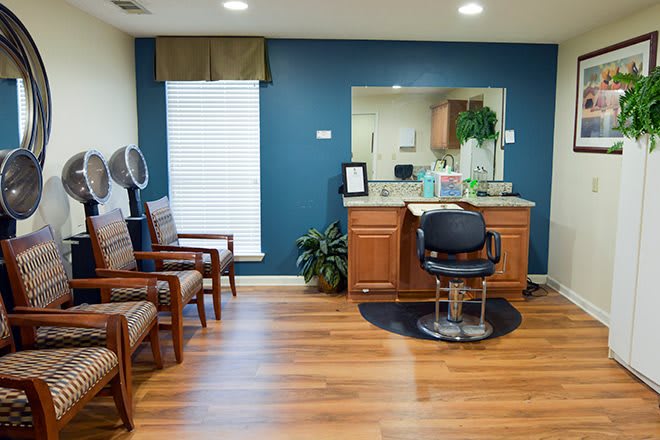 A well-organized hair salon with a styling chair, mirror, and seating area.