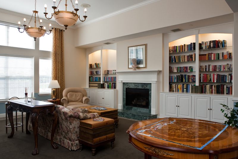 A cozy living room with built-in bookshelves, a fireplace, and comfortable seating.