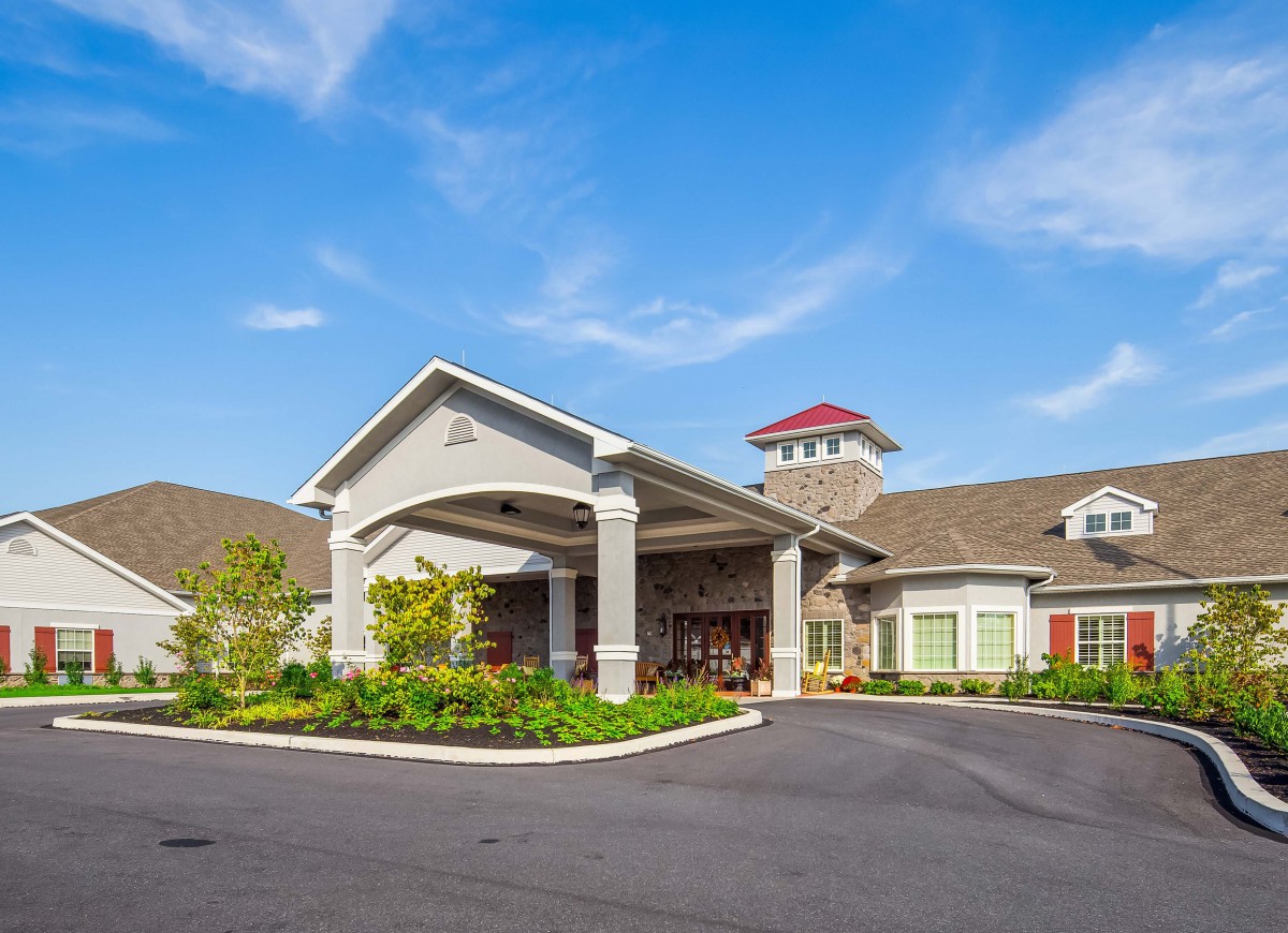 A beautifully designed residential building with a welcoming entrance and clear blue sky.