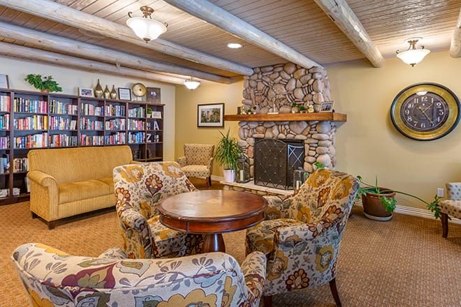 Cozy living room interior with a stone fireplace and colorful armchairs.