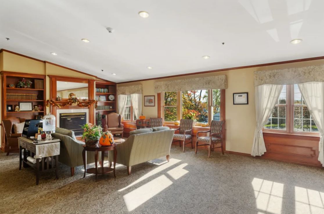 A cozy living room with elegant furnishings and ample natural light streaming through large windows.