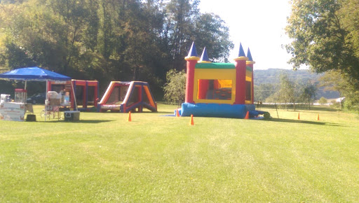 A colorful bounce house set up in a grassy area, perfect for outdoor fun.