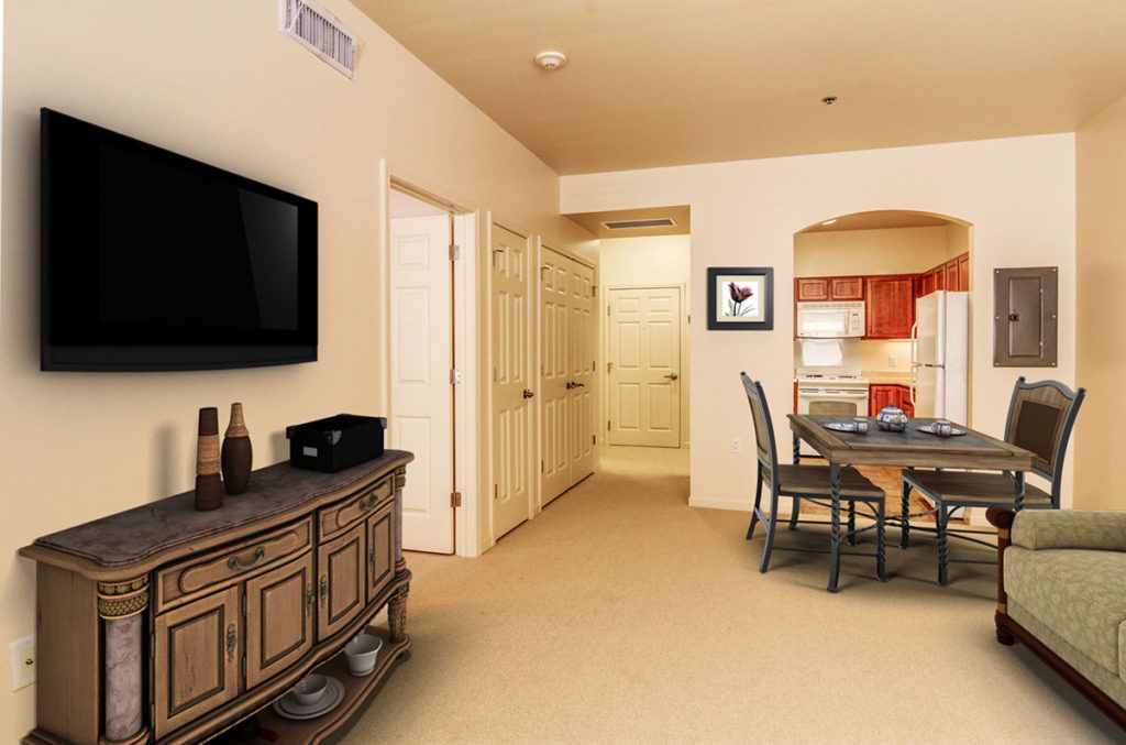 A cozy living and dining area with a view into the kitchen, featuring modern furniture and decor.