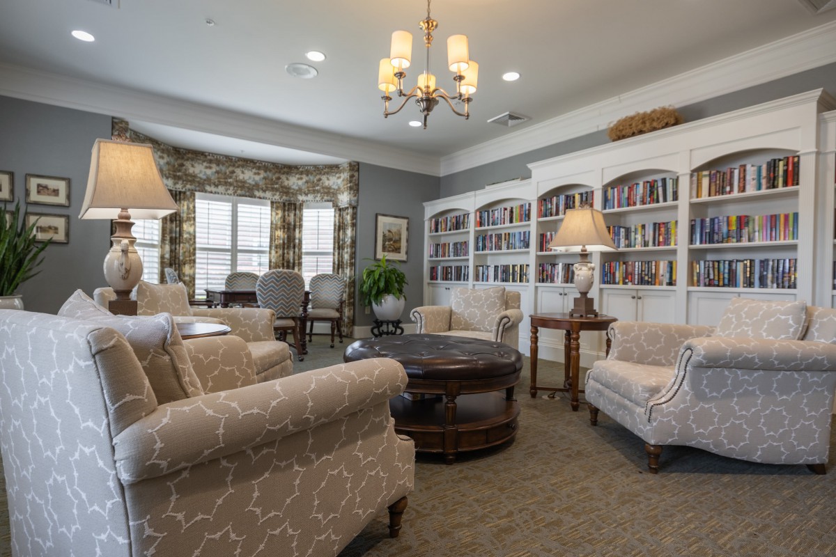 A cozy living room with comfortable seating, bookshelves, and elegant lighting.