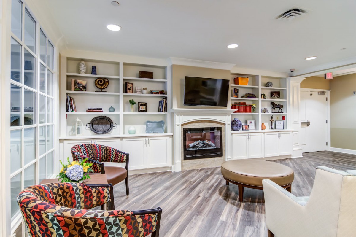 A modern living room featuring a fireplace, built-in shelves with decorative items, and a cozy seating area.