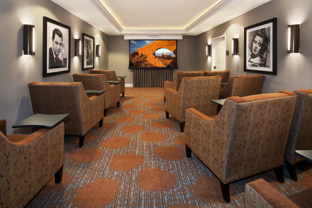 Cozy theater room with comfortable seating and a large projector screen.
