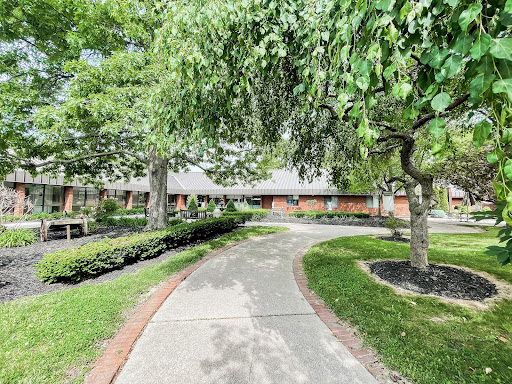 A serene pathway surrounded by lush greenery leading to a building.