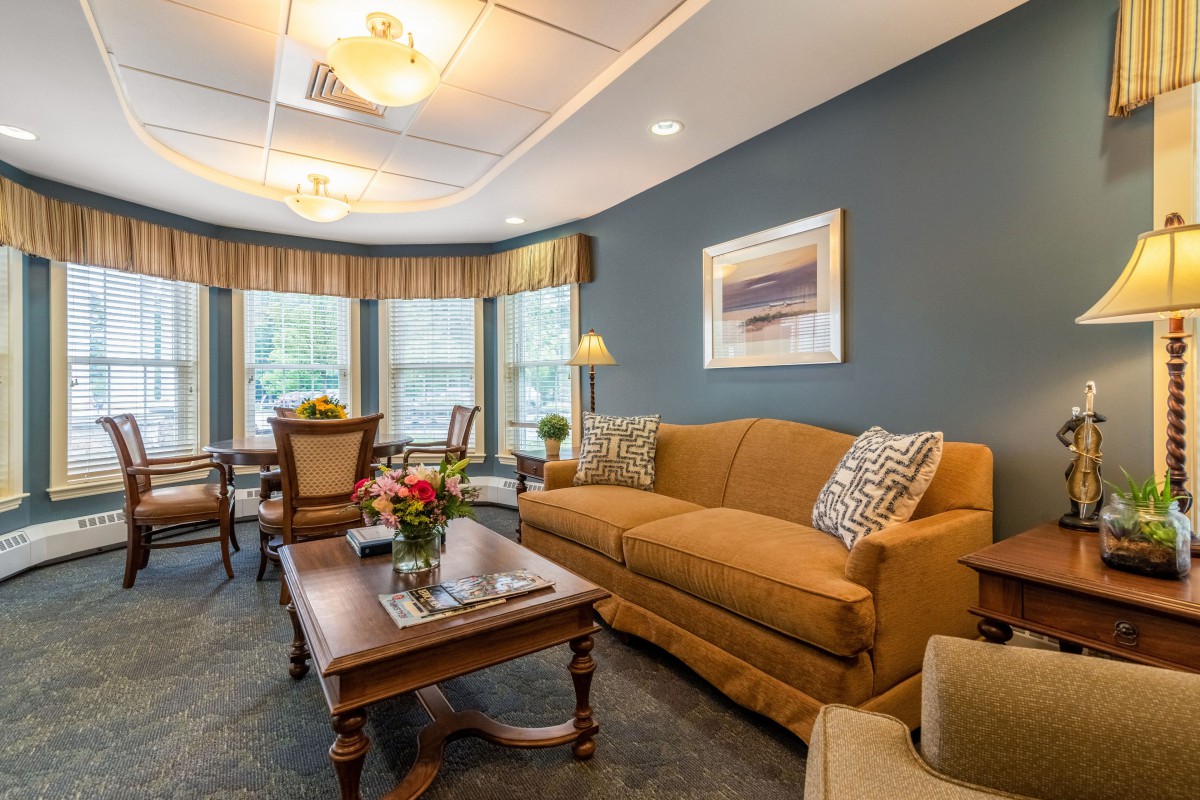 A cozy living room with a comfortable sofa, coffee table, and large windows.