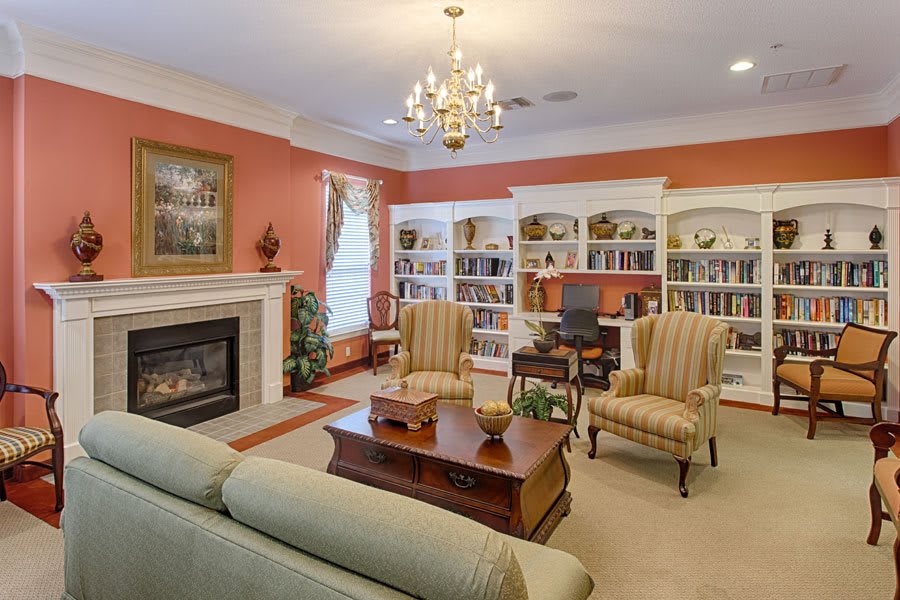 A cozy living room with a fireplace, bookshelves, and elegant furniture.