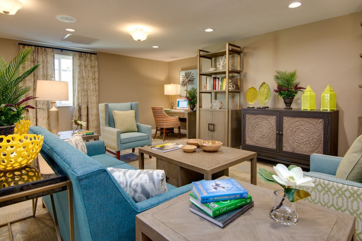 A cozy and elegantly designed living room featuring comfortable seating, a coffee table, and well-organized bookshelves.