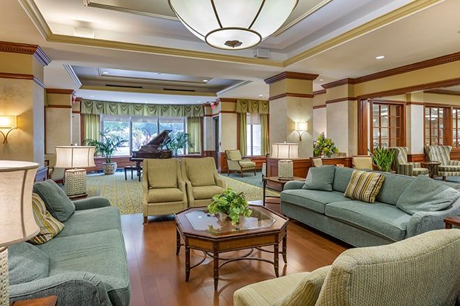 A spacious and elegantly designed lobby with comfortable seating and a grand piano.