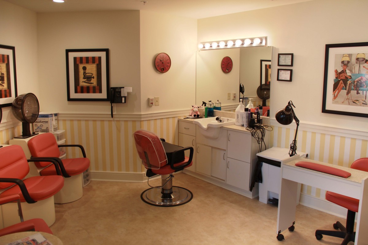 A cozy hair salon interior featuring styling chairs and a vanity with a mirror.