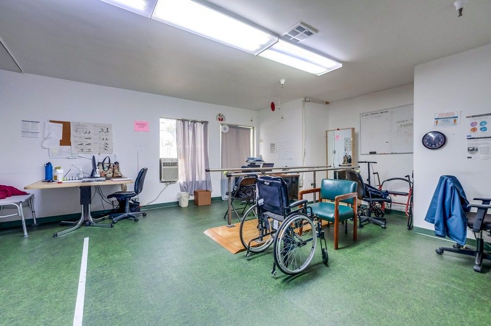 A rehabilitation room equipped with wheelchairs and physical therapy equipment.