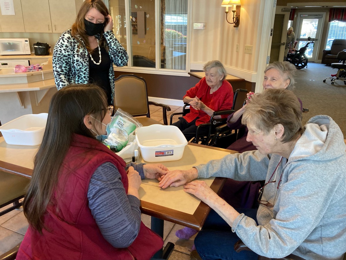 A group of people interacting and engaging in an activity at a table indoors.