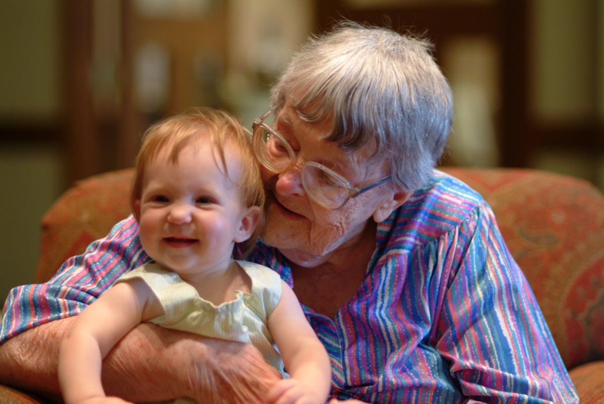 A joyful elderly woman embraces her smiling grandchild, capturing a moment of affection and happiness.