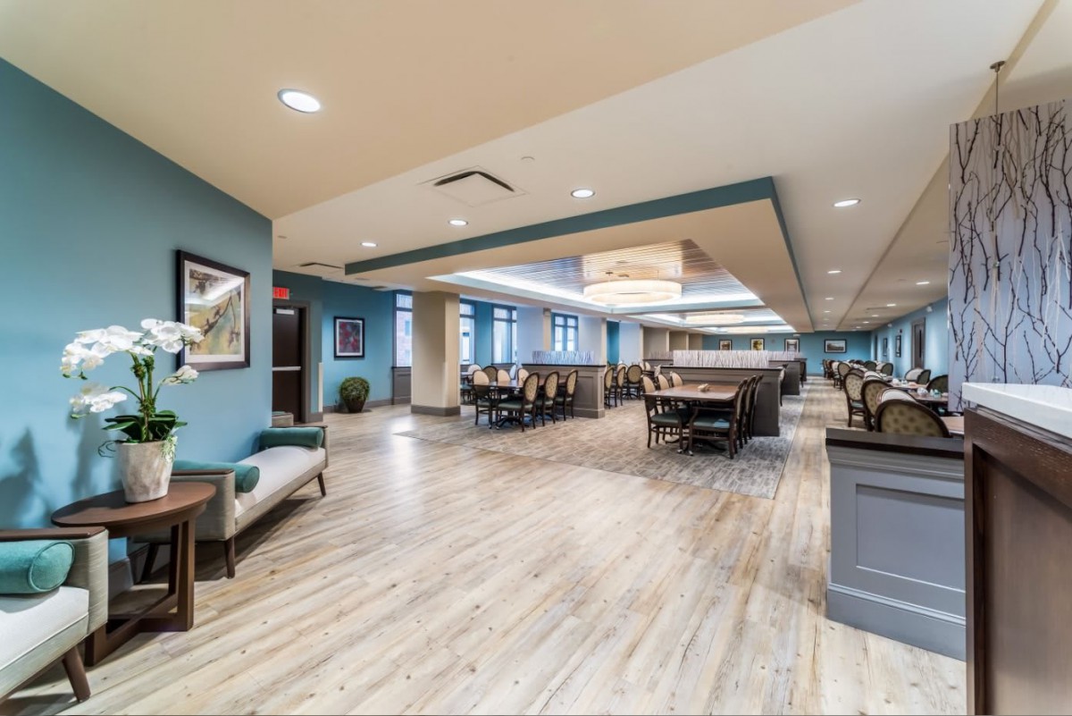 Spacious and modern dining area with elegant wooden flooring and ample seating.
