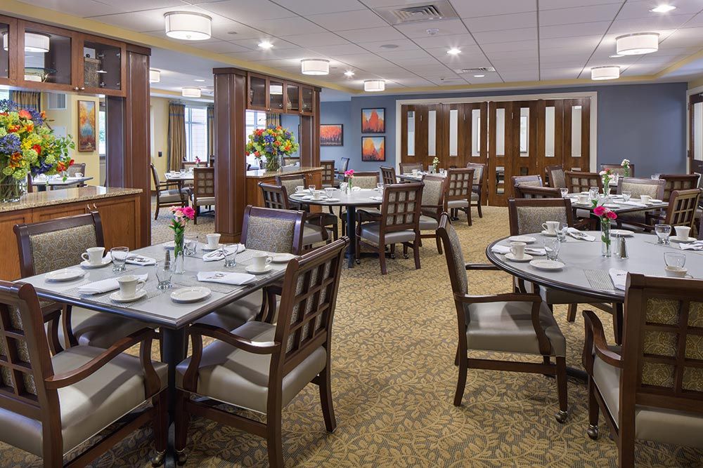 A well-appointed dining room with neatly arranged tables and chairs in a formal setting.
