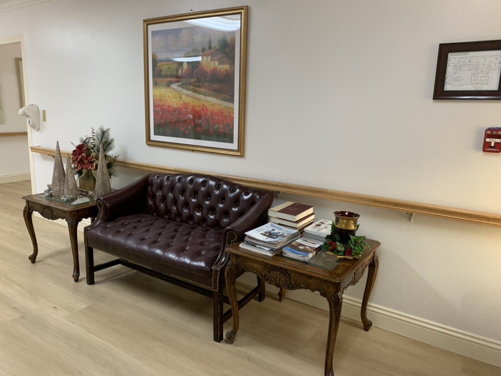 A cozy seating area with a leather sofa, decorative table, and framed artwork on the wall.