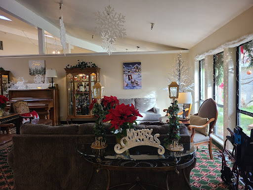 A cozy living room beautifully decorated for the Christmas season, featuring elegant furniture and festive poinsettias.