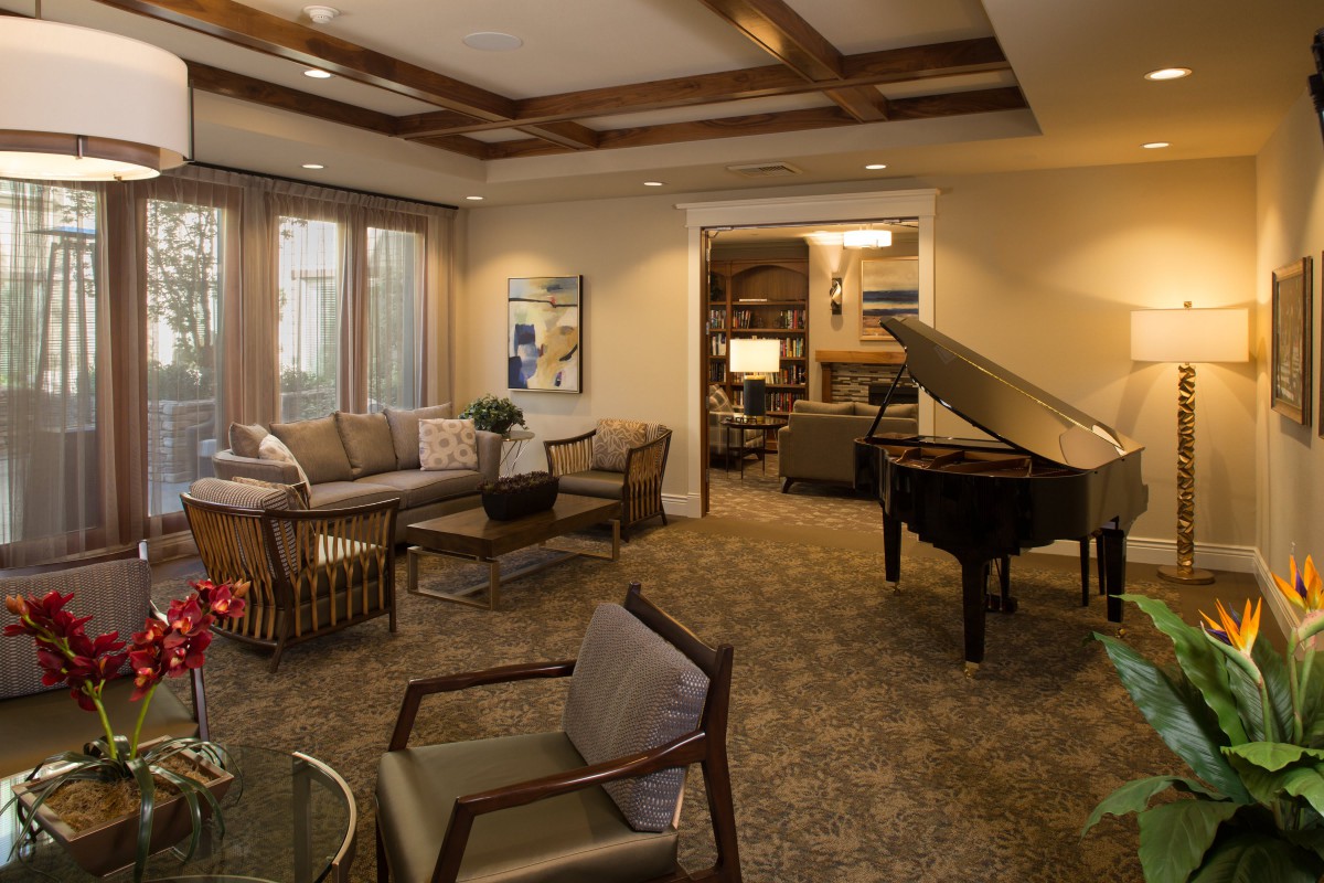 A cozy living room with a grand piano and elegant furnishings.