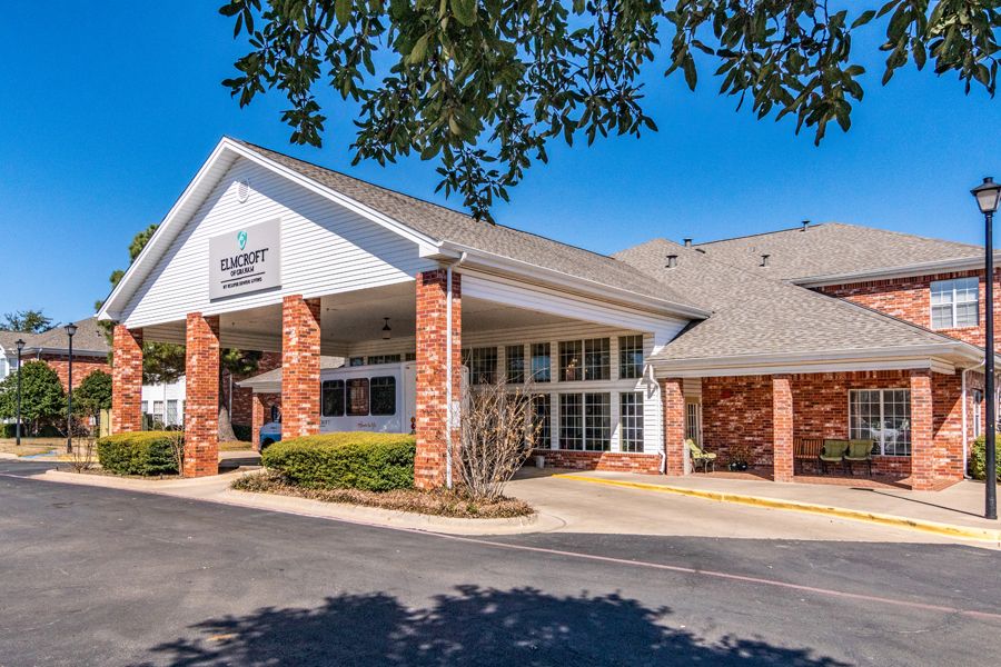 The entrance of a hotel building with brick columns and a peaked roof.
