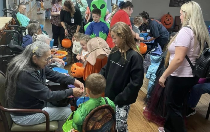 Children in costumes participating in a Halloween party with pumpkins and activities.
