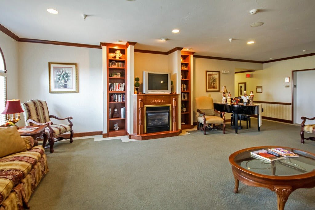 A cozy living room featuring a fireplace, built-in bookshelves, and comfortable seating.