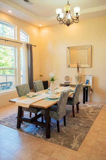 A beautifully arranged dining room filled with natural light, featuring a stylish table setting and modern furniture.